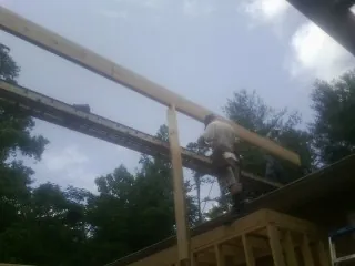 Carpenter setting a ridge beam over a new addition frame — Ice Dam Removal by Roofing Brothers in Beavercreek