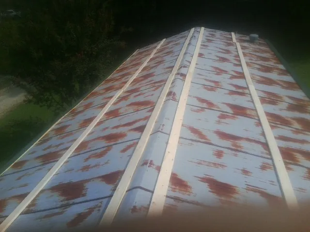 Rusted metal roof panels with new wood purlins before replacement — Storm Damage Roof Repair in Beavercreek by Roofing Brothers