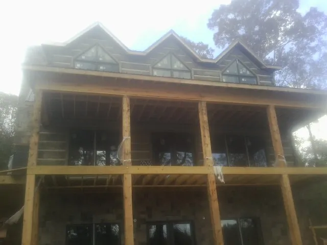 Dormers and porch framing on a large log home under construction — Roof Coating work by our crew in Beavercreek