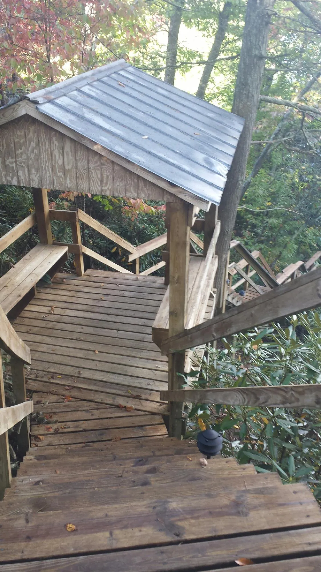 Metal roofed shelter over wooden steps on a wooded walkway — Skylight Repair & Installation work by our crew in Beavercreek